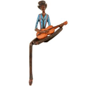 Handcrafted sitting jazz band figurine playing guitar with detailed attire and a joyful expression